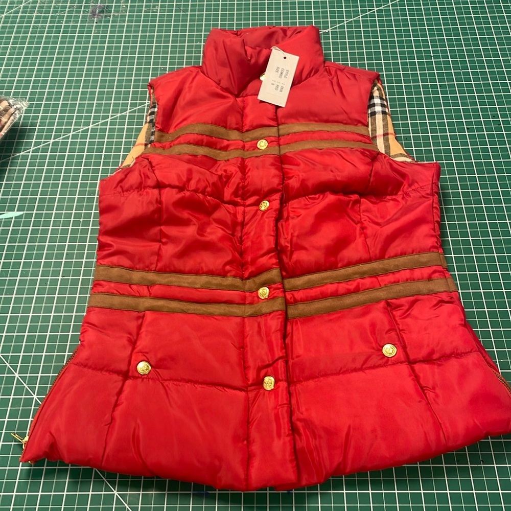 Red puffer vest with brown suede stripes and gold buttons.